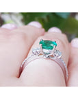 1.10 ct. round Colombian emerald ring with baguette side diamonds in 14K white gold.