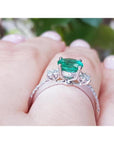 1.10 ct. round Colombian emerald ring with baguette side diamonds in 14K white gold.