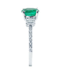 The side profile of this round cut emerald and diamond rings displays the top and accent diamonds on the shank.