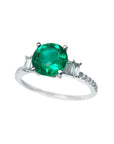 Round cut colombian emerald ring and side baguette diamond accents crafted in 14k white gold for women.
