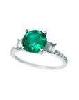 Round cut colombian emerald ring and side baguette diamond accents crafted in 14k white gold for women.