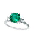 Round cut colombian emerald ring and side baguette diamond accents crafted in 14k white gold for women.
