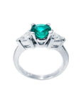 14K white gold ring with a vibrant round emerald center stone and two trillion-cut side diamonds.