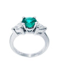 14K white gold ring with a vibrant round emerald center stone and two trillion-cut side diamonds.