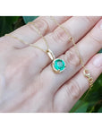 1.80 ct round natural emerald pendant necklace with halo diamonds in 14K yellow gold.