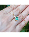 1.80 ct round natural emerald pendant necklace with halo diamonds in 14K yellow gold.