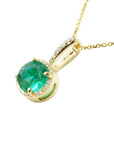 A 14k yellow gold round emerald pendant necklace displaying the top and gallery profile side.
