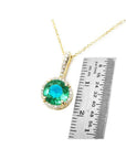 1.80 ct. round natural emerald pendant with halo diamonds on a 14K yellow gold chain.