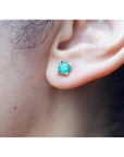 Round 1.09 ct. natural Colombian emerald stud earring in 14K gold basket setting on an ear.