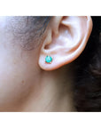 1.09 ct. round natural Colombian emerald stud earring in 14K gold basket setting on an ear.