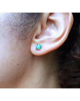 1.09 ct. round natural Colombian emerald stud earring in 14K gold basket setting on an ear.