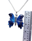 Blue agate butterfly pendant on a chain with a ruler for scale on a white background