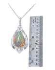 Pear-shaped Welo Ethiopian opal pendant in sterling silver with CZ accents, next to a ruler.