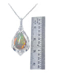 Pear-shaped Welo Ethiopian opal pendant in sterling silver with CZ accents, next to a ruler.