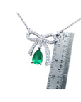 18K white gold bow-tie necklace with a pear-shaped deep green emerald.