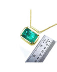 Women's Emerald solitaire necklace east west orientation rectangular prong set in a handmade setting in 18k yellow gold