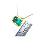 Emerald solitaire necklace with a deep green Muzo Colombian emerald in 18K yellow gold.