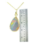 9.29 ct. Ethiopian opal pendant in 14K solid yellow gold, next to a ruler for scale.