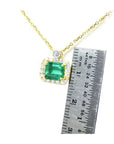 women's Necklace emerald east west orientation, crafted in 14k yellow gold, next to a ruler for measuring size