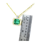1.31 ct emerald-cut Muzo Colombian emerald necklace with diamonds in 14K yellow gold.