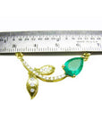 14K yellow gold twig necklace with a pear-cut Colombian emerald and diamond accents, measured by a ruler.
