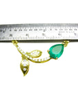 14K yellow gold twig necklace with a pear-cut Colombian emerald and diamond accents, measured by a ruler.