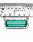 18K white gold Colombian emerald necklace with halo diamonds, East-West rectangular design, measured by a ruler.