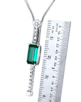 White gold necklace with a rectangular Colombian emerald and diamond accents, shown next to a ruler.
