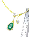18K yellow gold necklace with a pear-shaped Colombian emerald and diamond clusters, shown with a ruler.