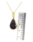 Teardrop Welo black opal pendant with red-orange fire, set in 14K yellow gold on a delicate chain.
