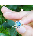 1.03 ct emerald cut blue sapphire solitaire ring in 14K white gold with rope frame and diamond shank.