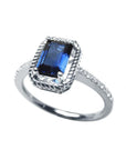 1.03 ct emerald cut blue sapphire solitaire ring in 14K white gold with rope frame and accent diamonds.