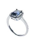 14K white gold solitaire ring with an emerald cut blue sapphire, rope frame, and accent diamonds.