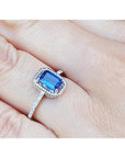 1.03 ct. emerald cut blue sapphire solitaire ring in 14K white gold with rope frame and accent diamonds.