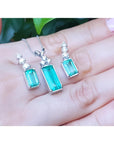 Emerald earrings and pendant set with accent diamonds in 14K white gold.