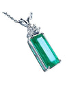 Emerald pendant with a rectangular medium bluish-green emerald and diamond accents in 14K white gold.