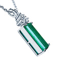 Right side profile of emerald pendant on a white gold chain against a white background