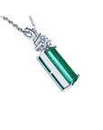 Right side profile of emerald pendant on a white gold chain against a white background