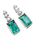 Pair of genuine emerald earrings with diamond accents on top, right side front top view.