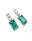 14K white gold dangle earrings with rectangular medium bluish-green emeralds and diamond accents.