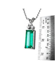 White gold pendant with a rectangular emerald and diamond accents, measured against a ruler.