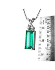 White gold pendant with a rectangular emerald and diamond accents, measured against a ruler.