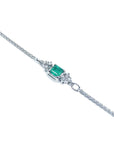 14K white gold bracelet with a central emerald-cut Colombian emerald and diamond accents.