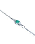 14K white gold bracelet with a central emerald-cut Colombian emerald and diamond accents.