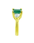 The side profile of a natural colombian emerald three stone ring for women in yellow gold