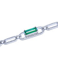 A gold paperclip bracelet with a genuine emerald gemstone on a lateral side view position.