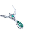Side angle view of a white gold pear cut emerald halo diamond necklace on a white background