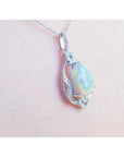 Opal pendant necklace on a pink skin background.
