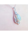 Pear-shaped rainbow Welo Ethiopian Opal pendant in 925 sterling silver with cubic zirconia accents.