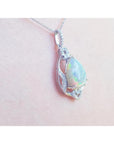 Pear-shaped rainbow Welo Ethiopian Opal pendant in 925 sterling silver with cubic zirconia accents.